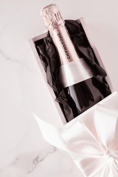 Celebration, drink and branding concept - Champagne bottle and gift box on marble, New Years, Christmas, Valentines Day or wedding holiday present and luxury product packaging for beverage brand