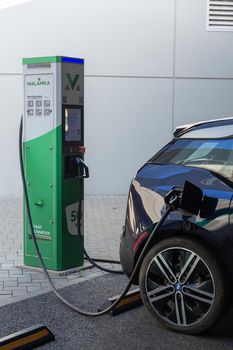 Grodno, Belarus - September 09, 2022: BMW i3 on 50kW fast charging spot Malanka on parking of the Triniti shoping mall - Car sharing commuter charging station. Charging technology industry transport which are the futuristic of the Automobile.