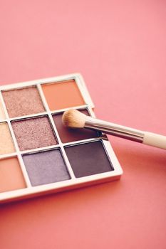 Cosmetic branding, mua and girly concept - Eyeshadow palette and make-up brush on orange background, eye shadows cosmetics product as luxury beauty brand promotion and holiday fashion blog design