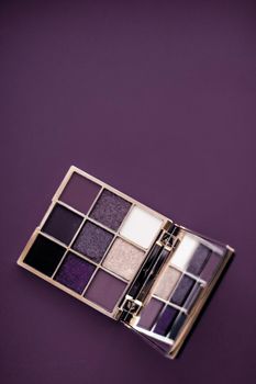 Cosmetic branding, mua and girly concept - Eyeshadow palette and make-up brush on purple background, eye shadows cosmetics product as luxury beauty brand promotion and holiday fashion blog design