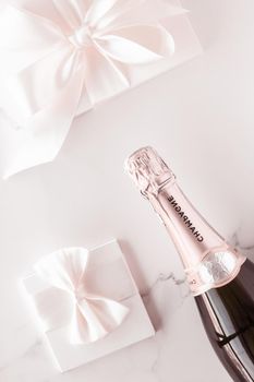 Celebration, drink and branding concept - Champagne bottle and gift box on marble, New Years, Christmas, Valentines Day or wedding holiday present and luxury product packaging for beverage brand