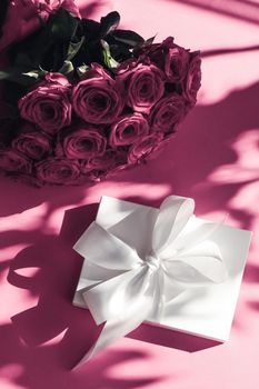 Happy holidays, luxe shopping and love gifts concept - Luxury holiday silk gift box and bouquet of roses on pink background, romantic surprise and flowers as birthday or Valentines Day present