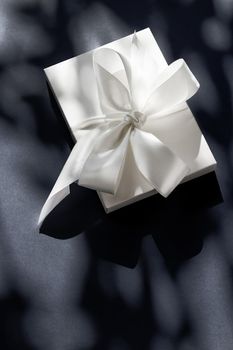 Anniversary celebration, shop sale promotion and luxe surprise concept - Luxury holiday white gift box with silk ribbon and bow on black background, luxe wedding or birthday present