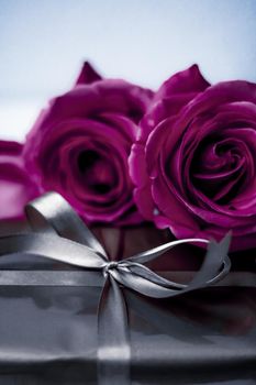 Luxurious design, shop sale promotion and happy surprise concept - Luxury holiday silver gift box and purple roses as Christmas, Valentines Day or birthday present