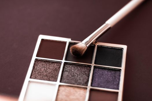 Cosmetic branding, mua and girly concept - Eyeshadow palette and make-up brush on chocolate background, eye shadows cosmetics product for luxury beauty brand promotion and holiday fashion blog design