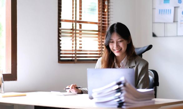 Portrait of smiling beautiful business asian woman working in office use computer with copy space