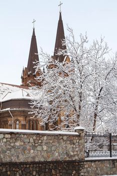 Roman catholic church with iron fence in a winter time