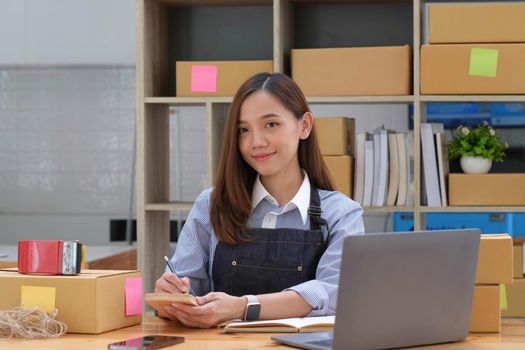 Portrait of Asian young woman SME working with a box at home the workplace.start-up small business owner, small business entrepreneur SME or freelance business online and delivery concept..