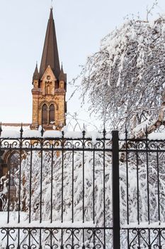 Roman catholic church with the iron fence in a winter time