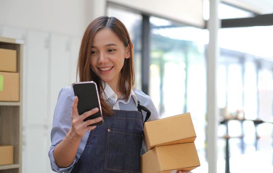 Startup small business entrepreneur SME, asian woman receive order on phone. Portrait young Asian small business owner home office, online sell marketing delivery, SME e-commerce telemarketing concept.