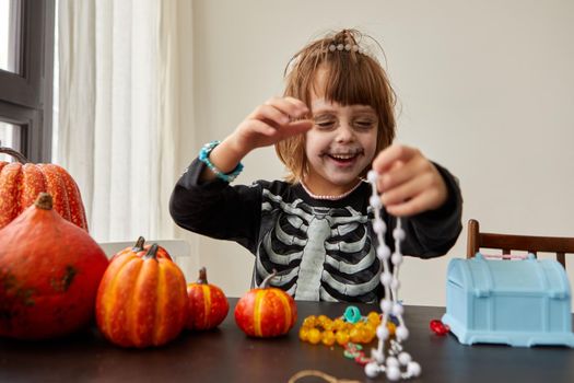 Happy laughing and smiling child boy dressing up with decorations before halloween holiday white background