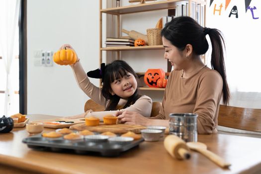 happy Halloween. family mother and daughter getting ready for holiday and baking cookies.