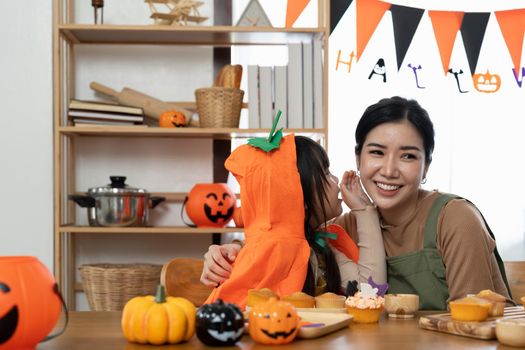 happy Halloween. family mother and daughter getting ready for holiday and baking cookies.