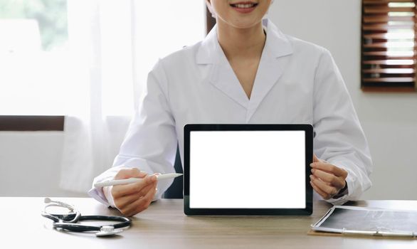 Portrait of experienced doctor woman cardiologist present modern technology white screen tablet she use consult patients wear white coat uniform stethoscope in examination room..