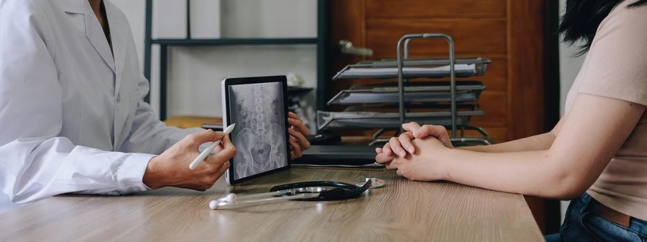 doctor and patient discuss chest x-ray results on digital tablet in clinics office.