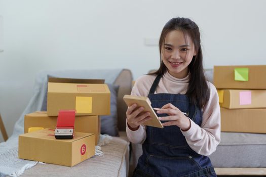 Asian SME business woman working at home office. online shopping concept.