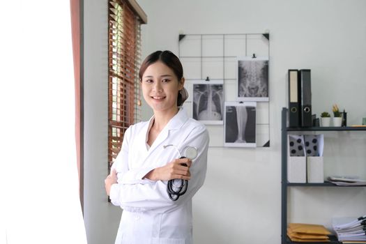 close up of asian female doctor standing arms crossed with stethoscope. Medical and Healthcare concept.