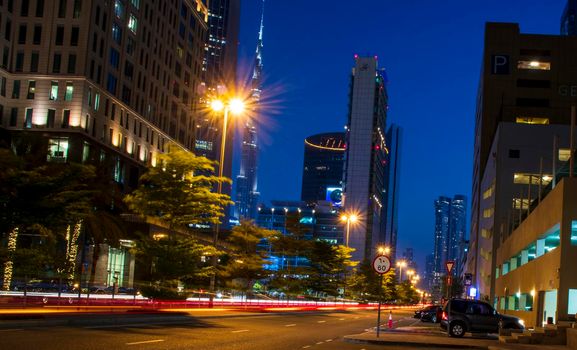 Light trails on Dubai Financial Center road. Address Sky view and Ritz Carlton hotel can be seen in the picture. Outdoors