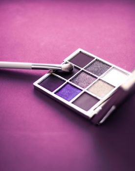 Cosmetic branding, mua and girly concept - Eyeshadow palette and make-up brush on purple background, eye shadows cosmetics product as luxury beauty brand promotion and holiday fashion blog design