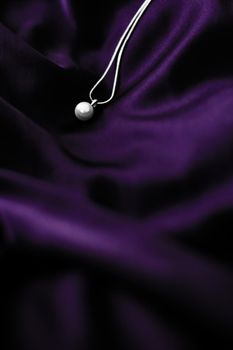 Jewellery brand, elegant fashion and bridal luxe gift concept - Luxury white gold pearl necklace on dark violet silk background, holiday glamour jewelery present