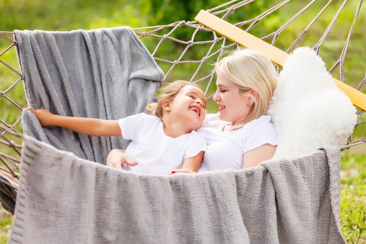 happy mother with her daughter lying in a hammock