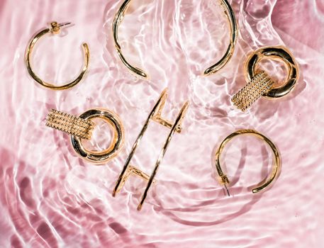 Jewellery branding, fashion gift and luxe shopping concept - Golden bracelets, earrings, rings, jewelery on pink water background, luxury glamour and holiday beauty design for jewelry brand ads