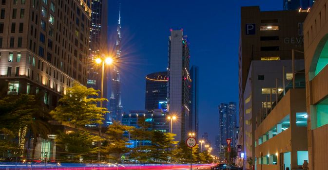 Light trails on Dubai Financial Center road. Address Sky view and Ritz Carlton hotel can be seen in the picture. Outdoors