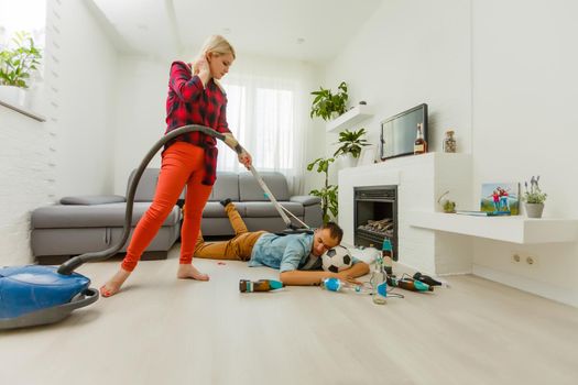 woman cleans the apartment while the man rests