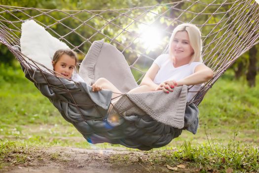 Mother And Daughter Sleeping In Garden Hammock Together