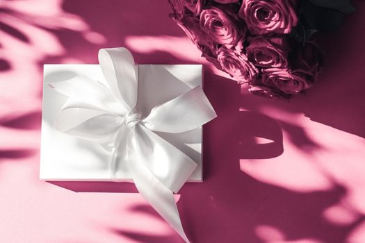 Happy holidays, luxe shopping and love gifts concept - Luxury holiday silk gift box and bouquet of roses on pink background, romantic surprise and flowers as birthday or Valentines Day present