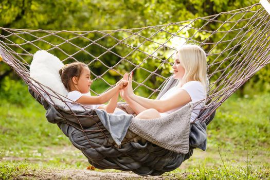 Mother's day. Happy mother and daughter relaxing together in a hammock