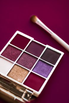 Cosmetic branding, mua and girly concept - Eyeshadow palette and make-up brush on wine background, eye shadows cosmetics product for luxury beauty brand promotion and holiday fashion blog design