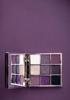 Cosmetic branding, mua and girly concept - Eyeshadow palette and make-up brush on purple background, eye shadows cosmetics product as luxury beauty brand promotion and holiday fashion blog design