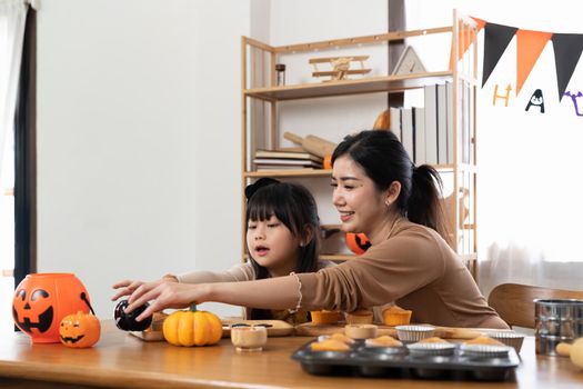 happy Halloween. family mother and daughter getting ready for holiday and baking cookies.