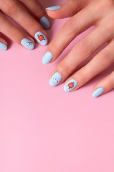 Female hands with winter snow manicure with stickers under a matte top on pink background.