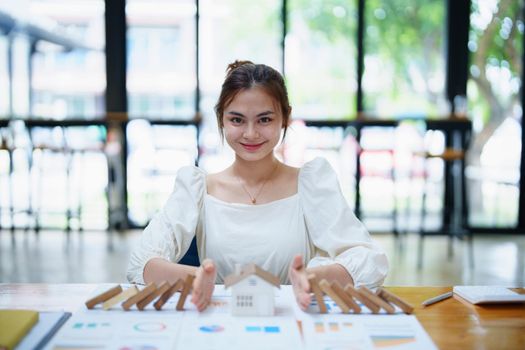 A portrait of a bank employee gesturing to protect a home from insurance to reduce the risk of investing, borrowing or buying a home