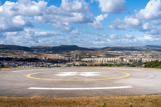 Helipad. Helicopter Landing Pad near emergency hospital in Portugal with cloud sky and city on background. Place to landing rescue helicopter near medical centre