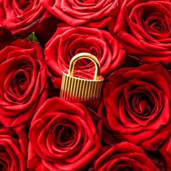 Holiday gift, flowers flatlay and happy relationship concept - Love lock for Valentines Day card, golden padlock and luxury bouquet of roses on red background