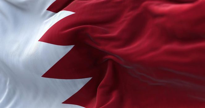 Close-up view of the Bahrain national flag waving in the wind. The Kingdom of Bahrain,[a] is an island country in Western Asia. Fabric textured background. Selective focus