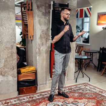 young businessman with a microphone at a public speaking training . business and education.