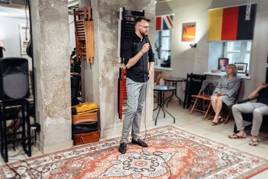 young businessman with a microphone at a public speaking training . business and education.