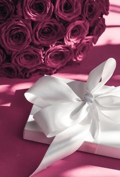 Happy holidays, luxe shopping and love gifts concept - Luxury holiday silk gift box and bouquet of roses on pink background, romantic surprise and flowers as birthday or Valentines Day present