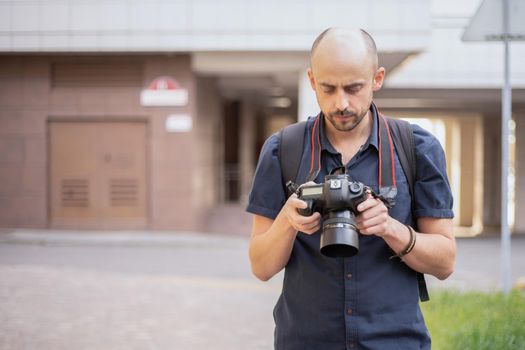 young man with a camera standing on a city street. photo with a copy space.