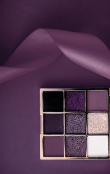 Cosmetic branding, mua and girly concept - Eyeshadow palette and make-up brush on purple background, eye shadows cosmetics product as luxury beauty brand promotion and holiday fashion blog design