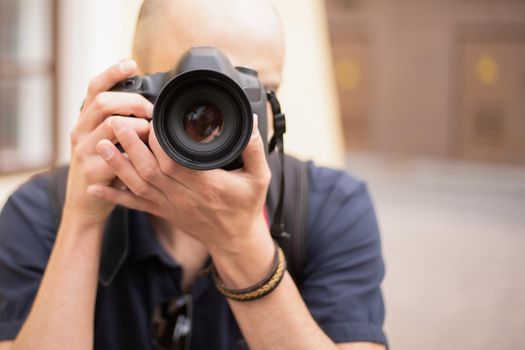 young man with a camera standing on a city street. photo with a copy space.