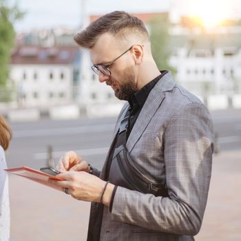 young man with a smartphone standing among a group of tourists. close-up