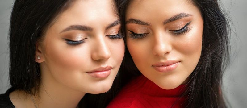 Portrait of young beautiful two women with long lashes and closed eyes after eyelash extensions