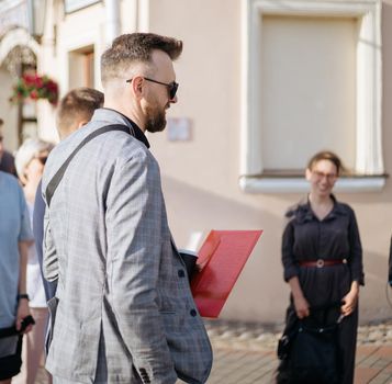 male guide standing among a group of tourists. side view.