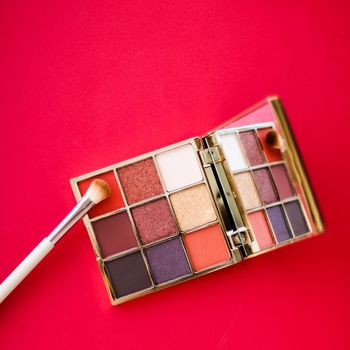 Cosmetic branding, mua and girly concept - Eyeshadow palette and make-up brush on red background, eye shadows cosmetics product for luxury beauty brand promotion and holiday fashion blog design