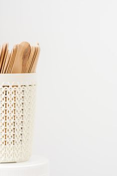 Sticks of wood for wax in white basket isolated on white background with copy space